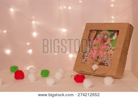 A Box With A Set Of Felt Toys Made Of Pigs, Dwarfs, Stars And Handmade Cookies Stands Against The Ba