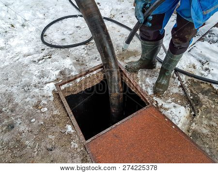 Worker Emptying The Septic Tank With A Sewage Cleaner Machinery At A Residentual House.