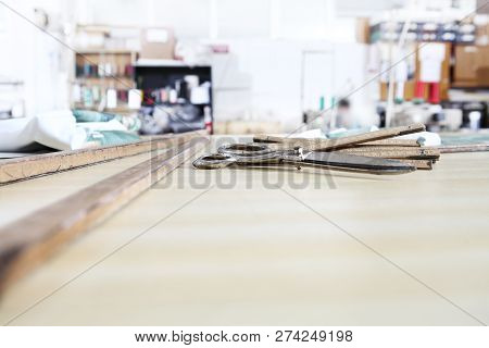 Tailor's Tools, Old Scissors, Wooden Meter And Ruler On The Sartorial Work Table