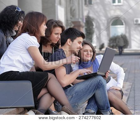 Group Of Fellow Students With Books And Laptop