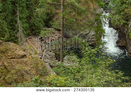 Deepblue Pool And Green Forest With Waterfalling Over Stones