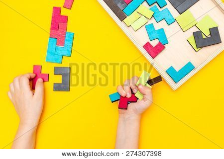 Tangram  On Yellow Background And Kids Hands. Flat Lay
