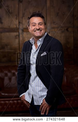 Excited Middle Aged Frenchman Smiling Happily While Standing In The Laconic Interior And Looking Del