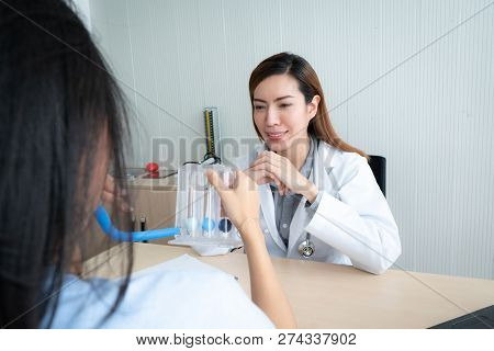 Female Doctor Explaining To Patient About To Use Incentive Spirometer
