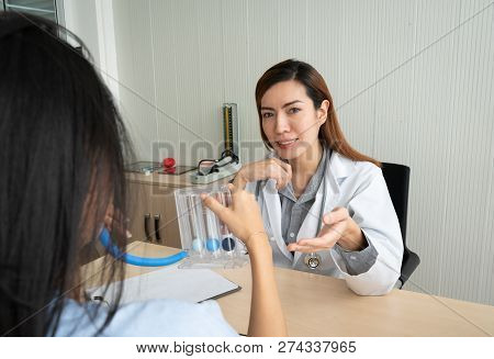 Female Doctor Explaining To Patient About To Use Incentive Spirometer