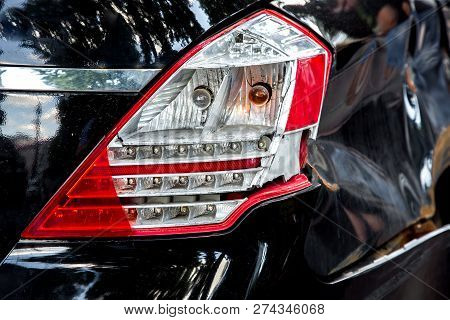 A Rear Lamp Damaged In The Incident And A Fender Of A Car, A Close-up Rear Light Of A Black Car.