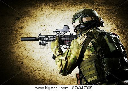 Fighter Of A Special Unit Is Aiming At The Sight Of The Machine Gun. Mixed Media