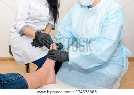 Podology Treatment. Podiatrist Treats Foot. Podiatry Doctor Or Dermatologist Treats The Patient In M