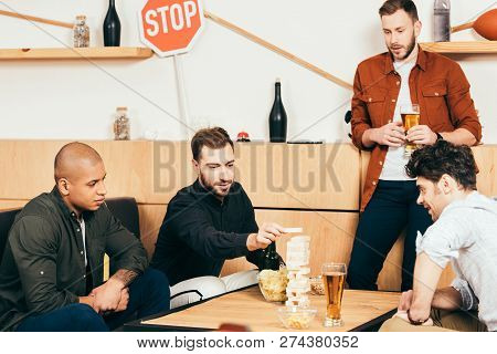 Multiethnic Friends Playing Blocks Wood Game In Cafe