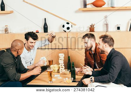 Multicultural Men Playing Cards While Spending Time Together In Cafe