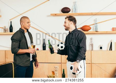 Side View Of Multicultural Men With Beer Having Conversation In Cafe
