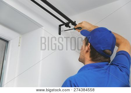 Handyman Services - Worker Installing Window Curtain Rod On The Wall