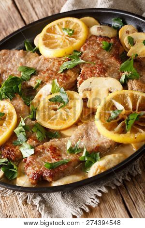 Lemon Veal Scaloppini With Mushrooms In A Sauce Close-up In A Pan. Vertical