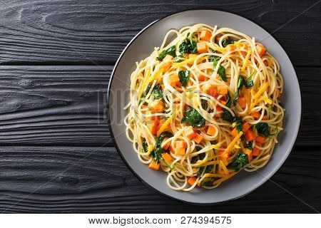 Italian Vegetarian Spaghetti With Pumpkin, Spinach And Cheddar Cheese Close-up On A Plate. Horizonta