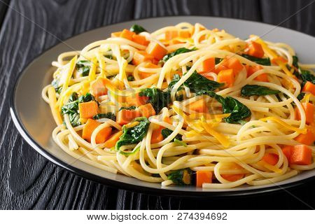 Low-calorie Lunch Of Spaghetti With Pumpkin, Spinach And Cheddar Cheese Close-up On A Plate. Horizon