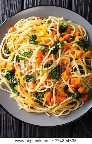 Low-calorie Lunch Of Spaghetti With Pumpkin, Spinach And Cheddar Cheese Close-up On A Plate. Vertica