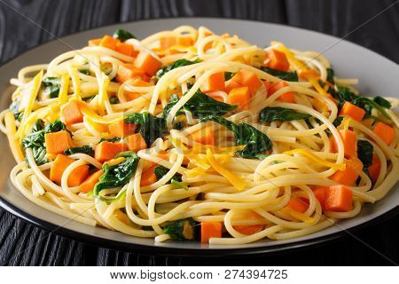 Healthy Autumn Meal Of Spaghetti With Pumpkin, Spinach And Cheddar Cheese Close-up On A Plate. Horiz