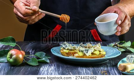 Cooking Bruschetta With Pears, Cheese And Honey On The Whole Grain Roasted Bread - On A Dark Black B