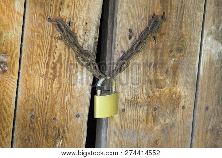 Lock On The Wooden Gates. Worn Out Wooden Plank Gates. Concept Of What Goes On Behind Closed Doors.