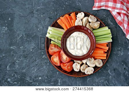Vegetable Tray With A Ranch Dip On A Dark Background. Raw Vegetable Mix Includes Sliced Mushrooms, C