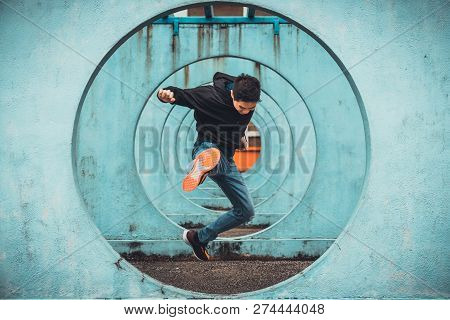 Young Asian Active Man Jumping And Kicking Action, Circle Looping Wall Background. Extreme Sport Act