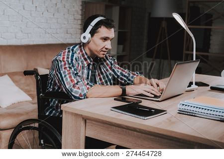 Young Disabled Man On Wheelchair Working At Home. Man On Wheelchair. Disabled Guy. Checkered Shirt. 