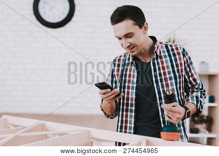 Young Man Assembling Wooden Bookshelf At Home. Wooden Bookcase. Selfmade Furniture. Man And Hobby. W