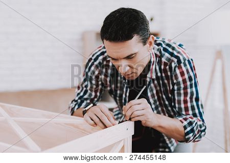 Young Man Assembling Wooden Bookshelf At Home. Wooden Bookcase. Selfmade Furniture. Man And Hobby. W