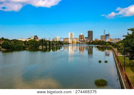 Skyline Of Rochester, New York Along Genesee River At Sunset.