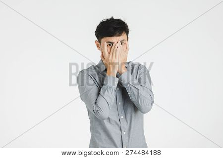 Young Asian Man Portrait Covering Mouth And Eye By His Hands As Secret Or Silence Sigh, Isolated On 