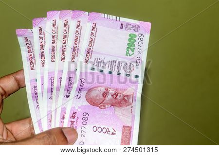 Selective Focus: Hand Holding Indian 2000 Rupee Notes Against Isolated Background. Close Up Of The N