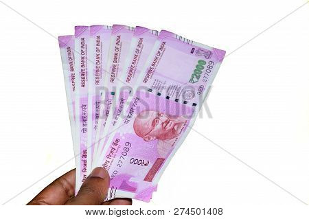 Selective Focus: Hand Holding Indian 2000 Rupee Notes Against White Background. Close Up Of The New 