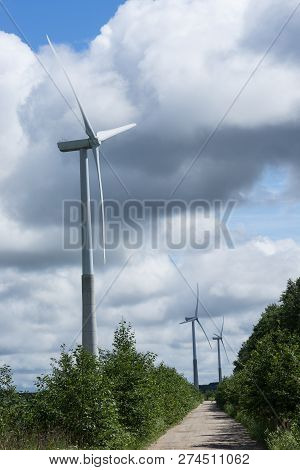 Ecology Concept: Blue Sky, White Clouds, Wind Turbine And Crop Field. Wind Generator For Electricity