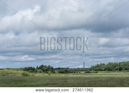 Ecology Concept: Blue Sky, White Clouds, Wind Turbine And Crop Field. Wind Generator For Electricity