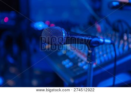 Microphone. Microphone On The Blurred Background Of The Audio Mixer Of The Musician. Night Show.