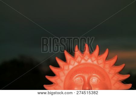 Closed Up Terracotta Sun Shaped Home Decor Item Against Twilight Dark Blue Sky