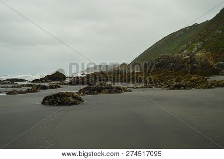 Remains Of Flysch Geological Formations On Los Quebrantos Beach On A Rain Day. July 30, 2015. Landsc