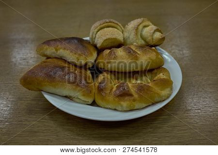 Delicious Fresh Baked Buns And Patty On A Clear Plate. Shot From Side Sligthly Above Angle.