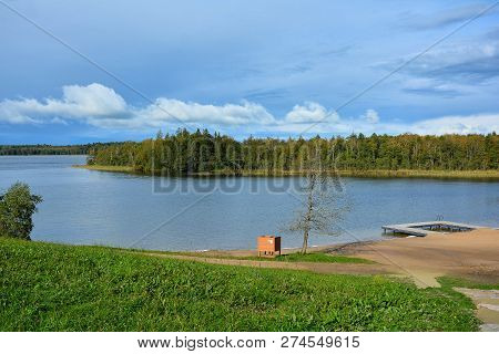 Blue Sky, Lake And Forest. Beach On The Lake Germantas, Lithuania. Autumn Landscape On A Sunny Clear