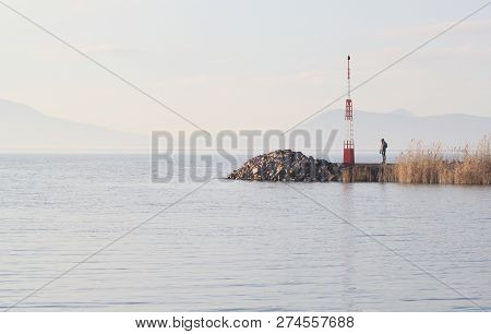 A Man On The Pier At The Lake Balaton In Winter