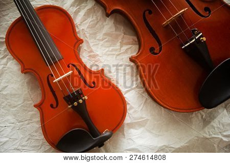 Two Different Size Of Violins Put On Background,shw Detail Of Front Side.