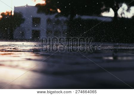 Rain Droplets Hitting The Ground And Bouncing Back