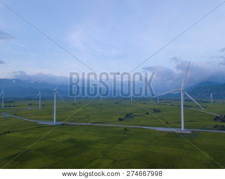 Wind Turbine Farm Or Windmill On Blue Sky. Turbine Green Energy Electricity Or Wind Turbine In A Gre