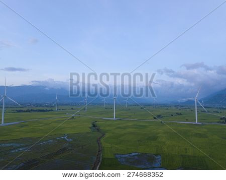 Wind Turbine Farm Or Windmill On Blue Sky. Turbine Green Energy Electricity Or Wind Turbine In A Gre