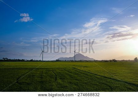 Wind Turbine Farm Or Windmill On Blue Sky. Turbine Green Energy Electricity Or Wind Turbine In A Gre