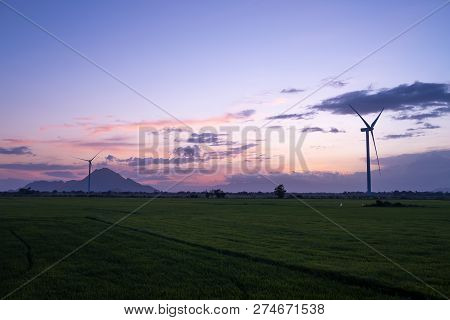 Wind Turbines Farm And Agricultural Fields On Blue Sky. Turbine Green Energy Electricity Or Wind Tur