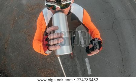Training An Athlete On The Roller Skaters. Biathlon Ride On The Roller Skis With Ski Poles, In The H