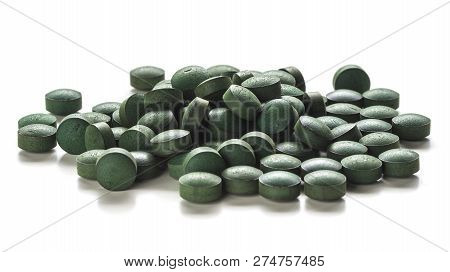 Close Up Of Organic Spirulina Tablets Over White Background.
