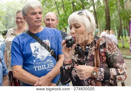 Komsomolsk-on-amur, Russia - August 19, 2018. Elderly Man Looks Like Attractive Elderly Woman Blows 
