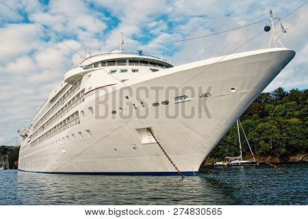 Cruise Ship. Large Luxury White Cruise Ship Liner On Sea Water And Cloudy Sky Background In Fowey